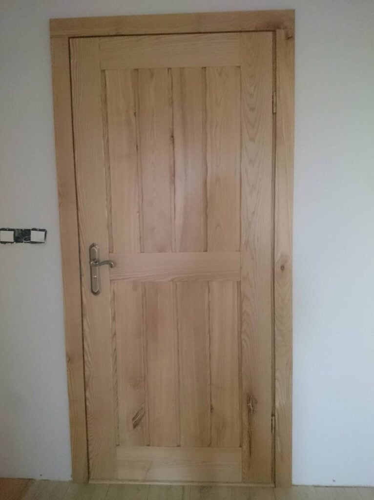 drewniane drzwi na tle białej ściany