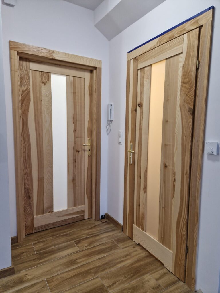 Drewniane drzwi z elementem szklanym na środku