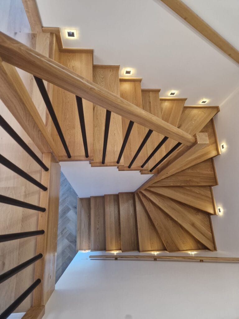 Drewniane schody zabiegowe z czarną balustradą