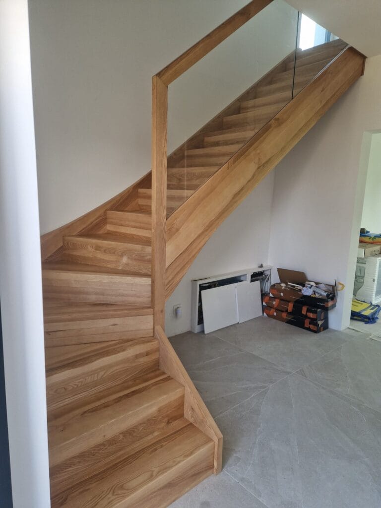 Schody zabiegowe ze szklaną balustradą