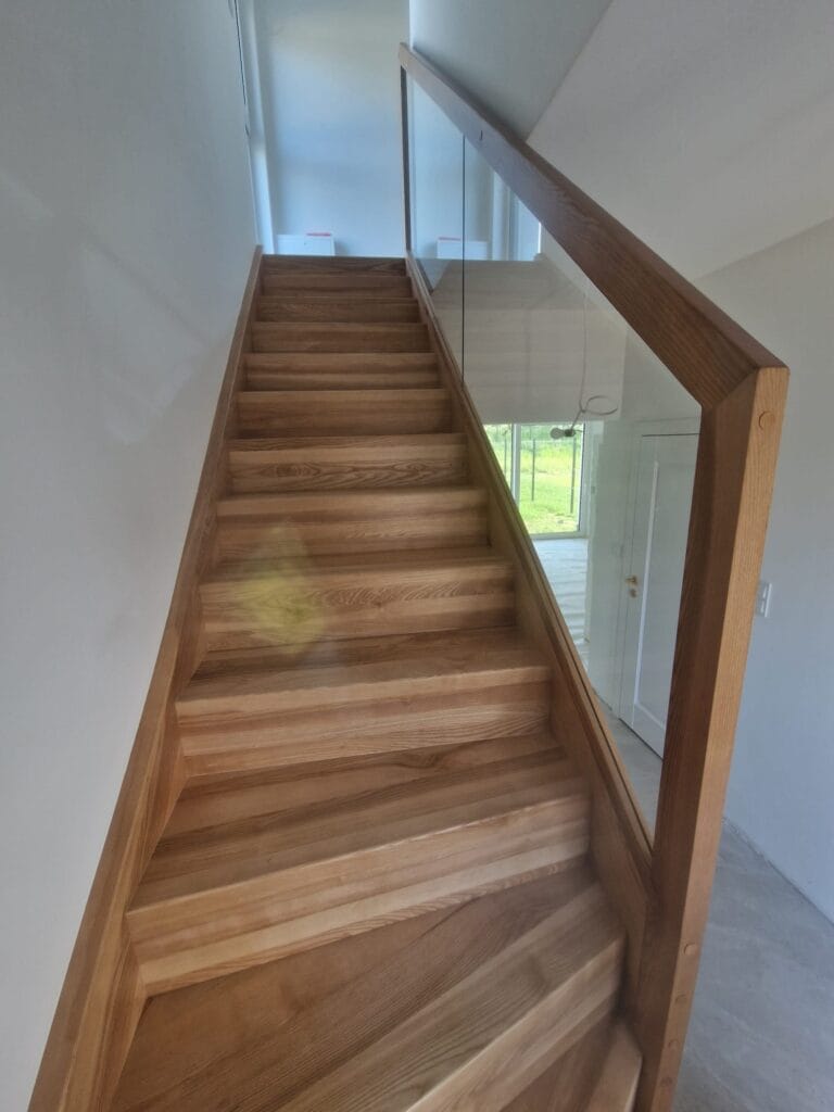 Drewniane schody ze szklaną balustradą